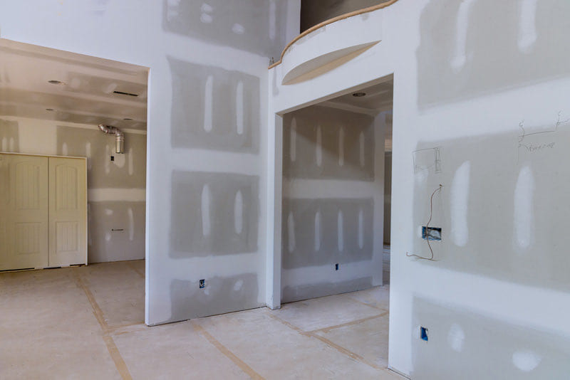 Sanded drywall hallway with a curved archway detail beside a finished closet opening